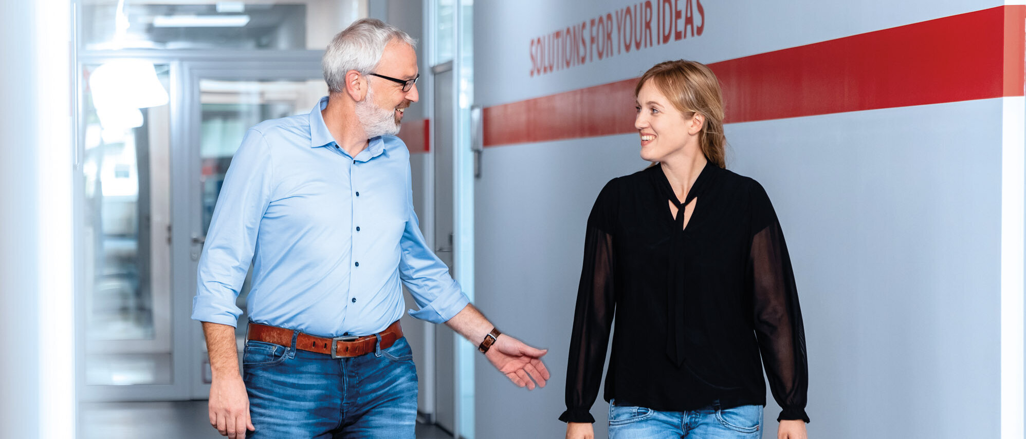 Zwei Mitarbeitende besprechen sich im Flur