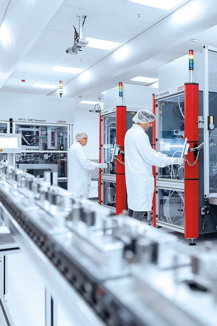 Mitarbeiter an einer Montagelinie in Automotive in der Sauberraumumgebung 