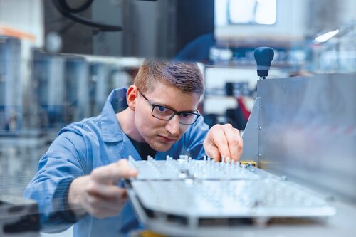 Mitarbeiter arbeitet an Bauteilen in der Mechanikproduktion mit CNC- und Lasertechnologien.