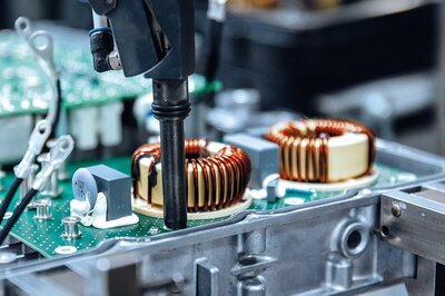 Automatisierte Fertigung von Spulen und elektronischen Bauelementen im Bereich induktiver Komponenten.
