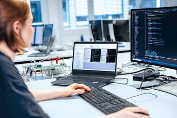 Mitarbeiter entwickelt Embedded Software am Computer.
