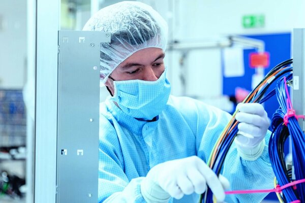 Mitarbeiter im Reinraum untersucht verschiedene Kabel 