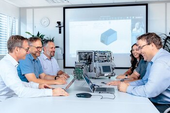 Team bespricht Projektmanagement-Aufgaben in einem Meeting mit Präsentation.