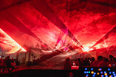 Lasershow; Rote Laser bilden einen Himmel über den Menschen 