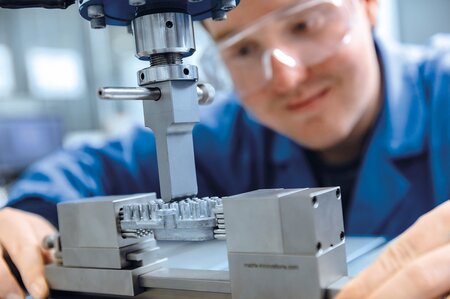 Prüfmaschine zur Bestimmung der Festigkeit von Werkstoffen und Bauteilen, mit eingespannten Metallteilen in einer Vorrichtung für Druck- und Zugtests.