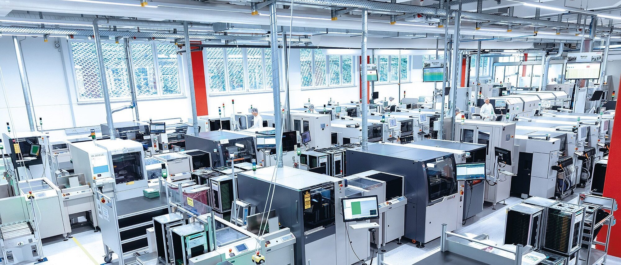 Produktionslinie der Zollner Elektronik AG mit modernen Maschinen und Monitoren für flexible Fertigung.