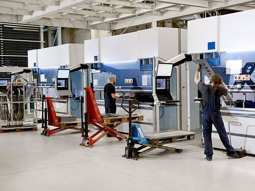 Automatisierte Produktionsanlage mit Mitarbeitenden in Industriehalle