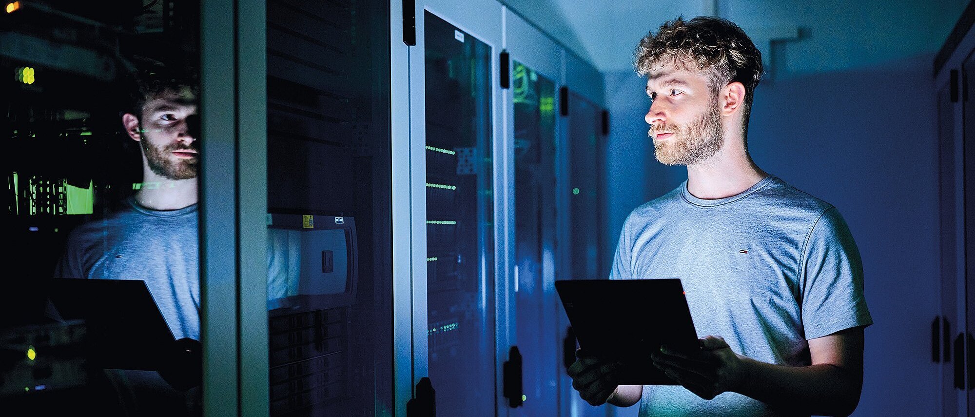 Mitarbeiter der Zollner Elektronik AG mit Tablet überprüft Serverracks in einem modernen Rechenzentrum für Datentechnik