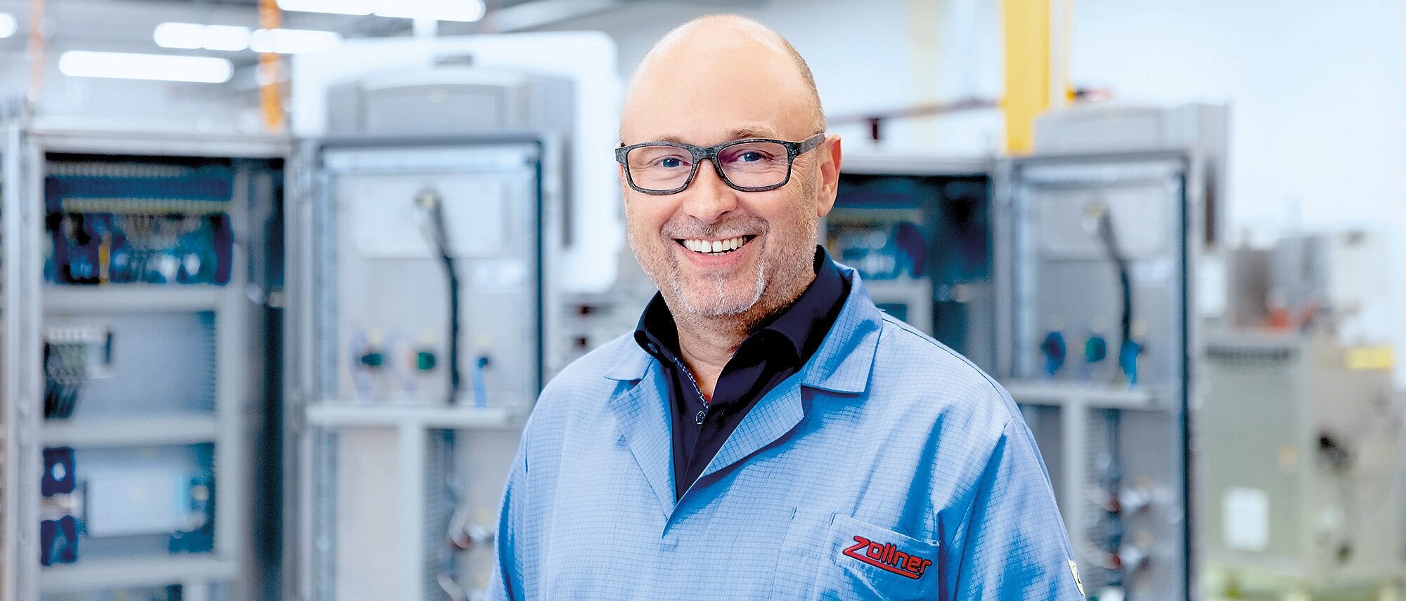 Mitarbeiter der Zollner Elektronik AG vor Schaltschränken in der Produktion.