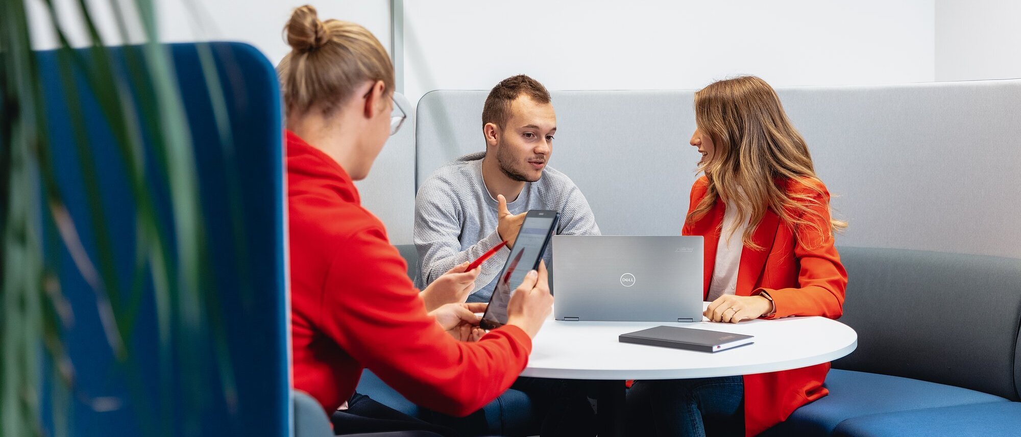 Drei Mitarbeiter der Zollner Elektronik AG besprechen Compliance-Themen mit Laptop und Tablet.