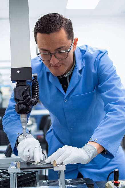 Mitarbeiter bei präziser Laborarbeit mit technischer Ausrüstung