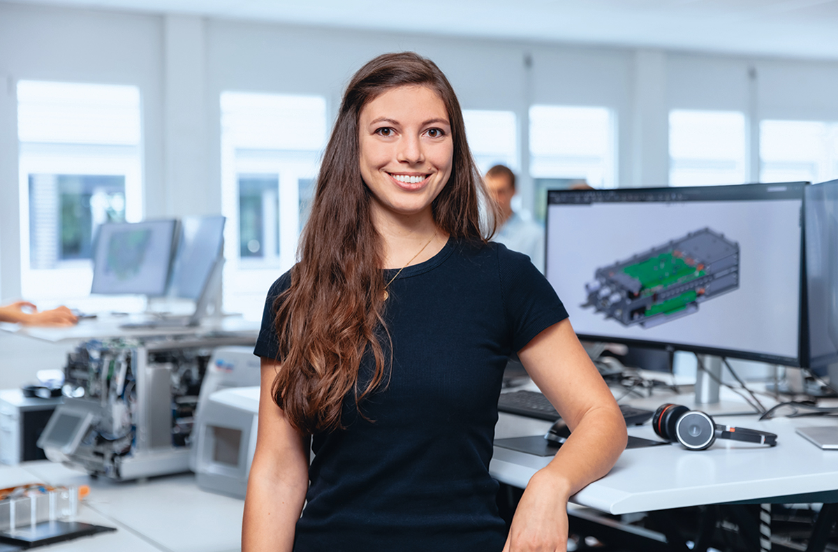 Mitarbeiterin steht vor einem Bildschirm mit CAD-Modell im Bereich Research & Development.