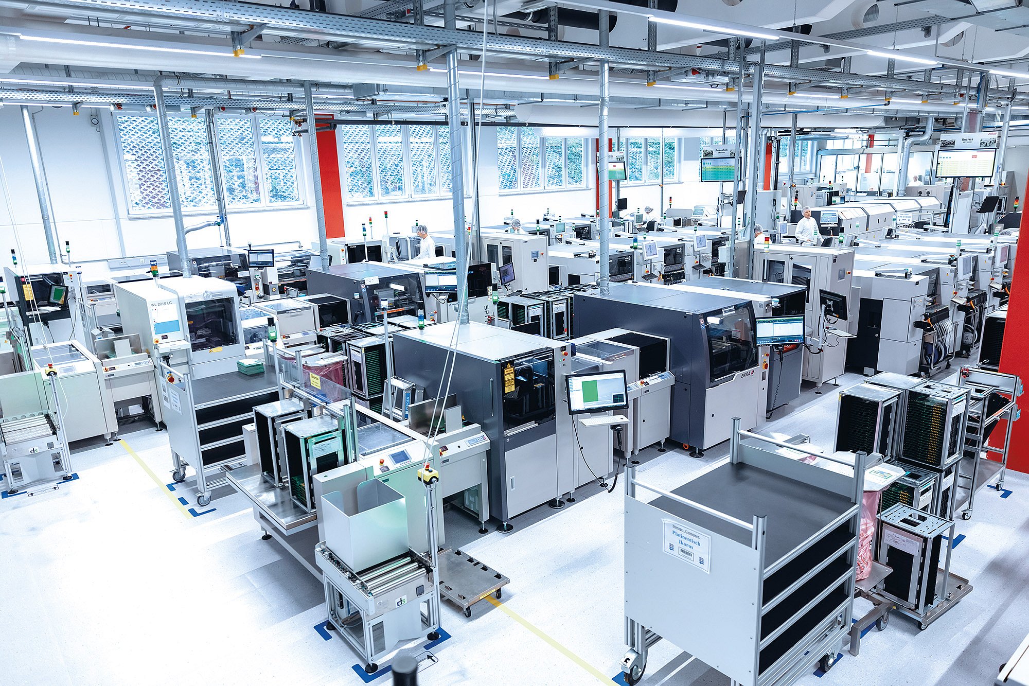 Produktionslinie der Zollner Elektronik AG mit modernen Maschinen und Monitoren für flexible Fertigung.